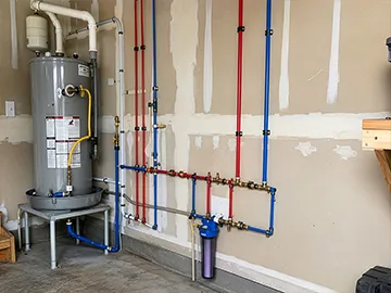 PEX water lines exposed near a water heater in a residential garage.